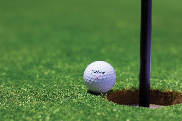 Golf ball on edge of hole